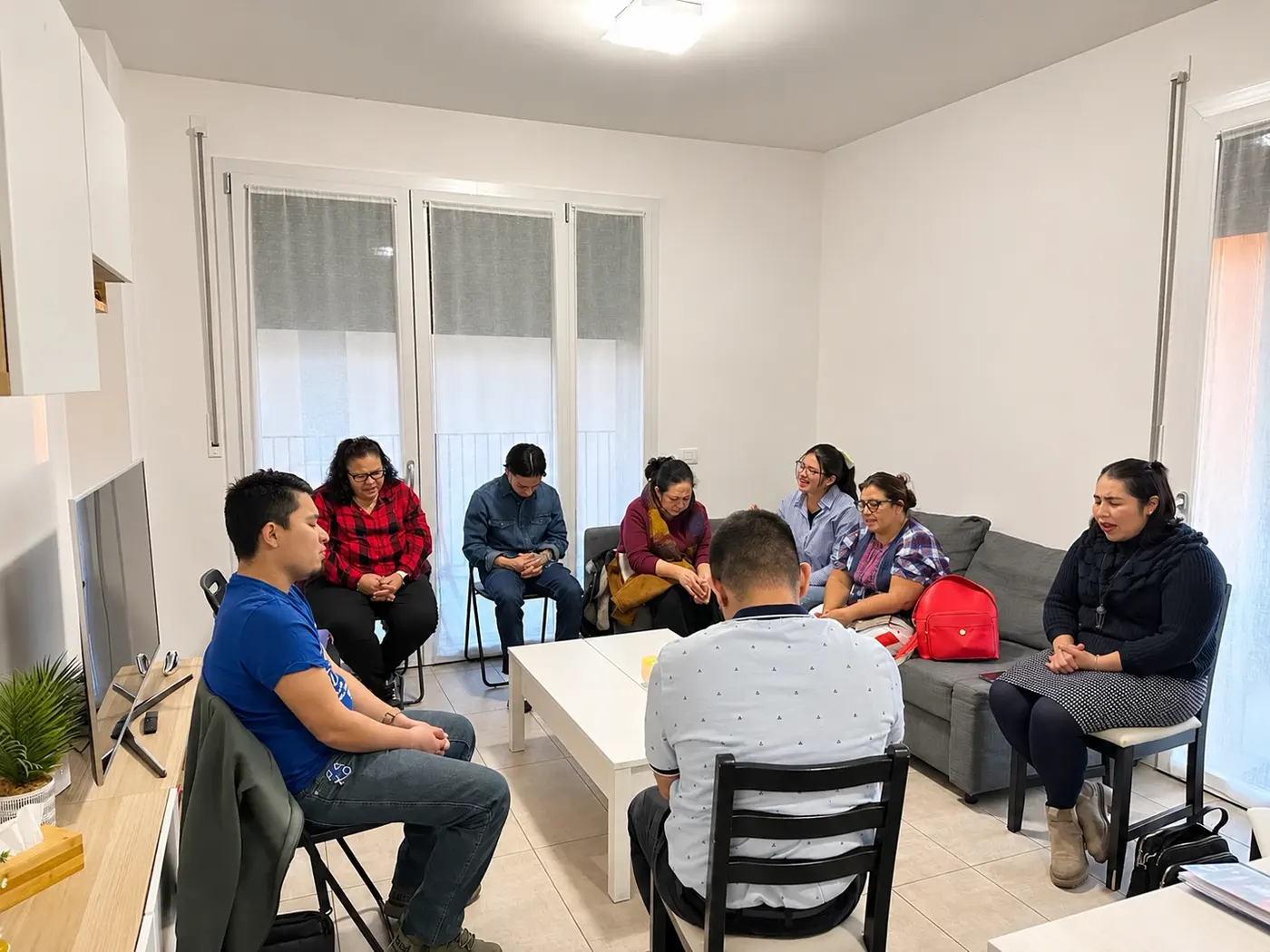 Un gruppo che prega in un soggiorno durante una cellula