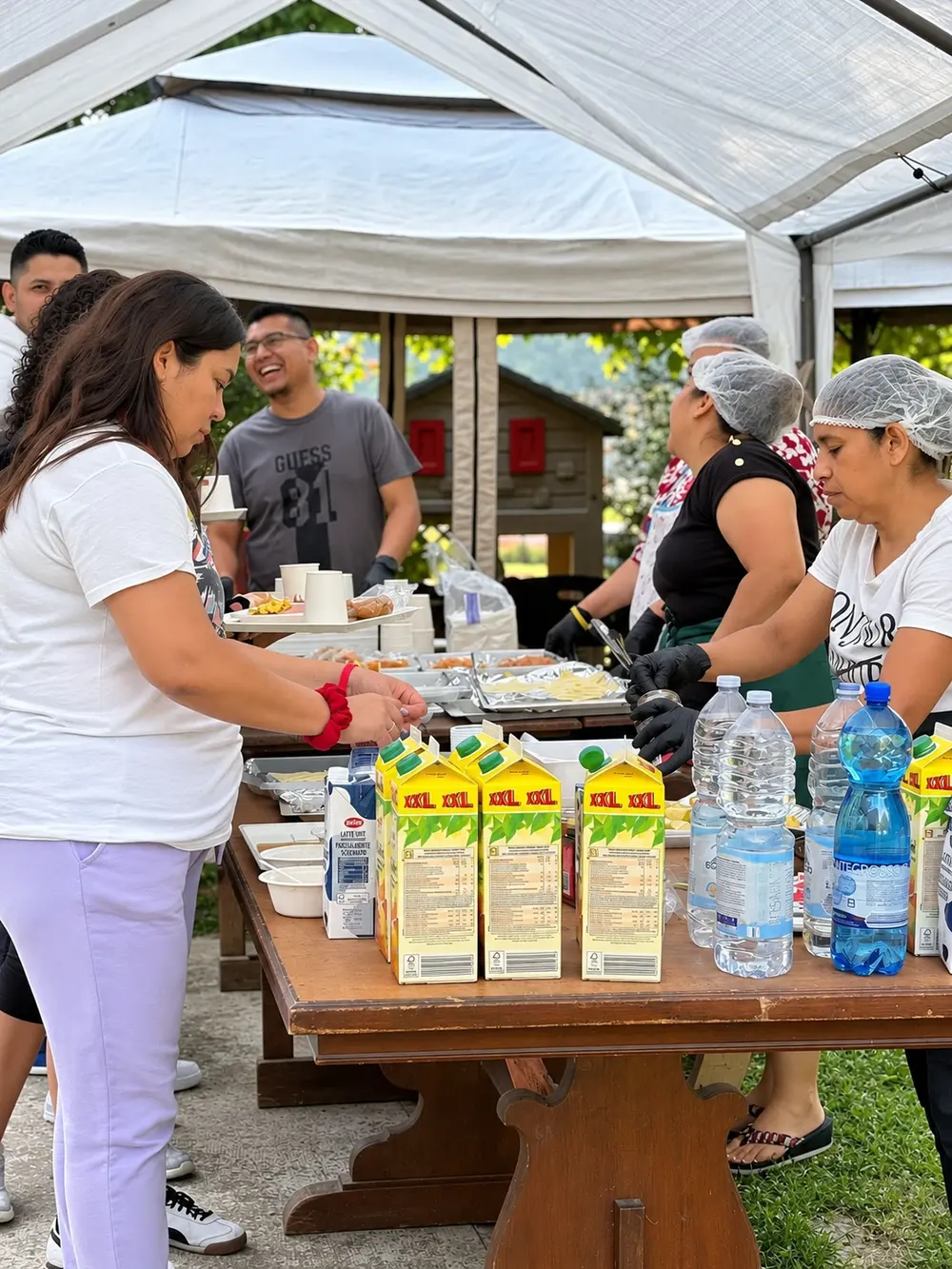 Volontari che servono il buffet sotto un gazebo